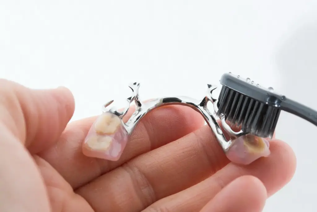 Partial dentures being cleaned with a toothbrush
