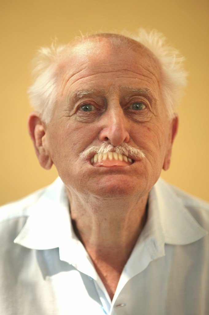 Silly man with dentures partially in mouth